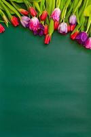 colorful Bouquet tulips on green background. Flat lay, top view, copy space photo