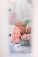 a Newborn baby sleeping on a blanket. Age 1 week photo