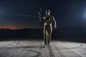 A professional soldier in full military gear striding through the dark night as he embarks on a perilous military mission photo
