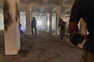 A professional cameraman captures the intense moments as a group of skilled soldiers embarks on a dangerous mission inside an abandoned building, their actions filled with suspense and bravery photo