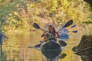 A group of friends enjoying having fun and kayaking while exploring the calm river, surrounding forest and large natural river canyons photo