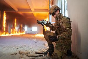 Soldier in action near window changing magazine and take cover photo