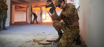 Soldier in action near window changing magazine and take cover photo