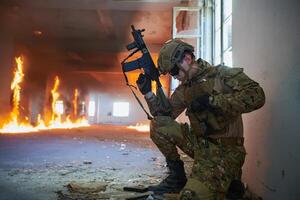 Soldier in action near window changing magazine and take cover photo