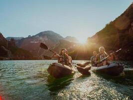 A group of friends enjoying fun and kayaking exploring the calm river, surrounding forest and large natural river canyons during an idyllic sunset. photo