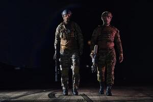 Two professional soldiers marching through the dark of night on a dangerous mission, epitomizing their unwavering bravery, unwavering teamwork, and the high-stakes intensity of their specialized photo