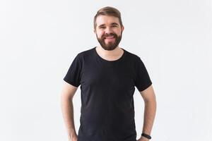 Cheerful guy smiled happily, has excited expression over white studio background. Holidays, youth, emotions concept. photo