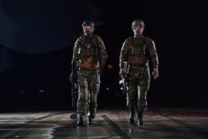 Two professional soldiers marching through the dark of night on a dangerous mission, epitomizing their unwavering bravery, unwavering teamwork, and the high-stakes intensity of their specialized photo