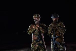 Two professional soldiers marching through the dark of night on a dangerous mission, epitomizing their unwavering bravery, unwavering teamwork, and the high-stakes intensity of their specialized photo