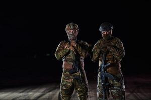 Two professional soldiers marching through the dark of night on a dangerous mission, epitomizing their unwavering bravery, unwavering teamwork, and the high-stakes intensity of their specialized photo