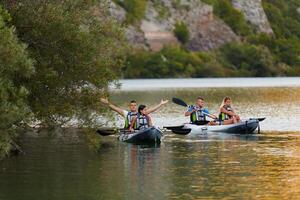 A group of friends enjoying having fun and kayaking while exploring the calm river, surrounding forest and large natural river canyons photo