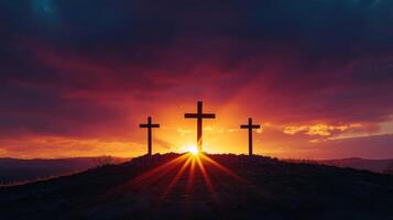 Dramatic sunset behind three crosses on hill silhouette photo