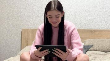 Young girl using tablet on bed, changing facial expressions video