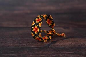 Tied woven friendship bracelets with bright colorful patterns handmade of thread isolated on white background photo