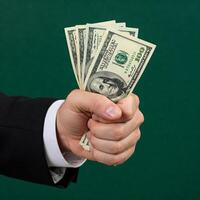 A man in a suit holding a bundle of money photo