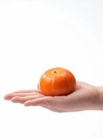 A person holding an orange in their hand photo