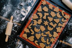Unbaked Christmas cookies lie on a baking sheet on the table. Top view photo