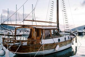 Wooden sailing yacht moored at the pier against the backdrop of mountains photo