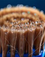 Close-up View of Water Droplets Resting on a Brush With Natural Bristles Against a Blue Background photo