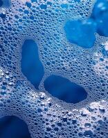 Bubbles Floating on a Vibrant Blue Surface Create Intricate Patterns and Textures in a Cleaning Setting photo