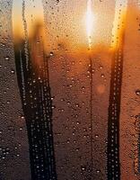 Beautiful Sunset View Through a Water Droplets Covered Glass, Showcasing Natural Patterns and Colors in the Evening Light photo