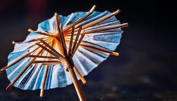 Miniature Cocktail Umbrella Resting on a Dark Surface With a Textured Background photo