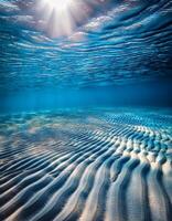 Sunlight Filters Through Water Creating Beautiful Patterns on Sandy Ocean Floor in Vibrant Underwater Scene photo