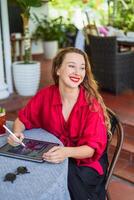 artist and illustrator made an idea about a concept of her drawing, sitting by the table with electronical tablet and stylus photo