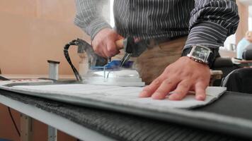 Man irons clothes on ironing board with blue steaming iron 2 video