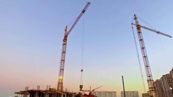 Two cranes are standing in front of a building video