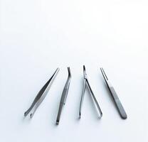 Four different types of surgical instruments on a white surface photo