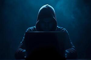 Cyber hacker attack concept. Abstract digital hacker man with a laptop. Male criminal, hoodie and ready for coding, cyber-attack and programming photo