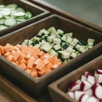 A wooden tray with cucumbers, carrots, and other vegetables photo