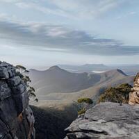 A man standing on a rock overlooking the mountains photo