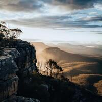 The sun shines on a mountain range with trees and rocks photo