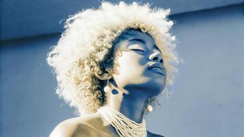 A woman with a white afro and necklace photo