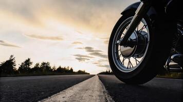 A motorcycle is parked on the road at sunset photo