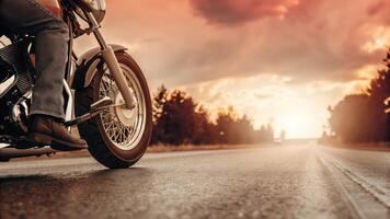 A person riding a motorcycle on a road at sunset photo