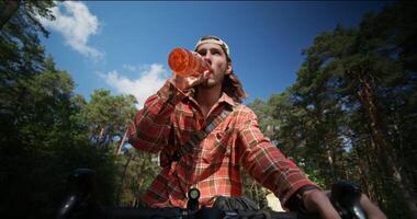 A man on a bicycle drinking from a bottle photo