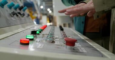 A person is standing in front of a control panel photo