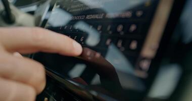 A person is typing on a touch screen in a car photo