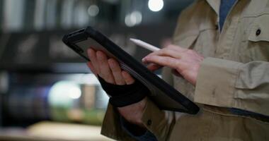 A man holding a pen and using a tablet computer photo