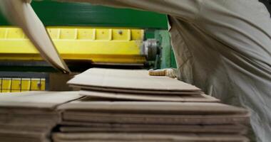 A man is working on a stack of paper photo