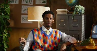 A man in an office wearing an orange and blue vest photo