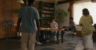 A group of people in a room with a table and chairs photo