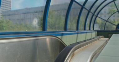 A long escalator with a bench on the side photo