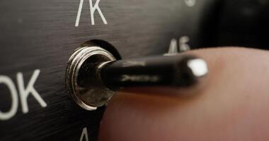 A close up of a button on a black and white control panel photo