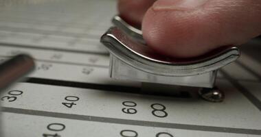 A person is using a metal object to adjust a dial photo