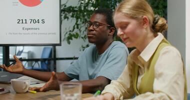 Two people sitting at a table with a presentation on the screen photo