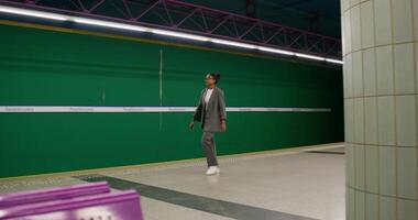 A man in a suit is walking down a subway platform photo